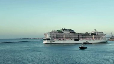 Uçsuz bucaksız okyanus ile bu geniş manzaradaki görkemli yolcu gemisi arasındaki zıtlığa hayran olun. Geniş sular ve gemilerin zarafeti etkileyici bir sahne için birleşiyor.. 