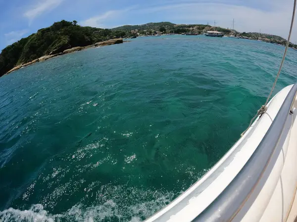 Güneş ışığı dalgaları tenha bir adada yuvarlanıyor. Güneş altında hafif dalgalar pırıl pırıl parlıyor..