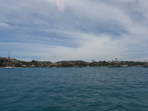 Sakin bir göldeki geleneksel tahta yelkenli beyaz yelkenli klasik bir ahşap tekne çarpıcı bir turkuaz gölde yüzer..