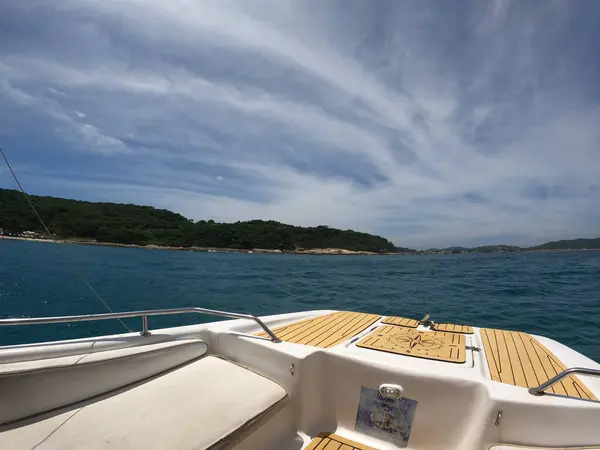 Sürat teknesi Zümrüt Denizi 'nde yarışıyor Yüksek hızlı tekne yolculuğu çarpıcı turkuaz suda beyaz bir dalga izi bırakıyor.