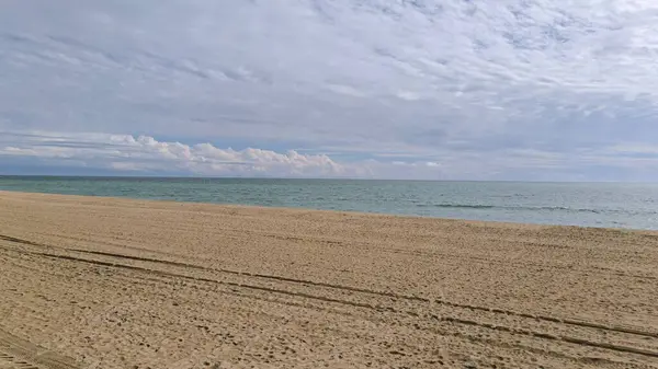 Yumuşak Kum 'da ayak izleri. Huzurlu bir sahne kıyıya doğru giden taze ayak izleri yakalıyor..