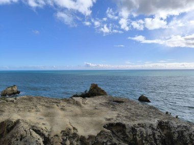Güneş Işığı Kayaları Bir Turkuaz Deniz Pelerini Çerçeveliyor 