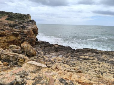 Kayalıklı ve Yuvarlanan Dalgalı Kasvetli Kıyı Sahnesi