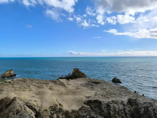 Güneş Işığı Kayaları Bir Turkuaz Deniz Pelerini Çerçeveliyor 