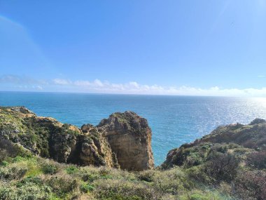 Kıyıda parlayan tropikal dağların altın saat manzarası. 