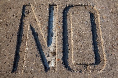 The text 'No' embossed in concrete.
