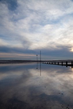 Reflections on Westcliff beach, near Southend-on-Sea, Essex, England, United Kingdom