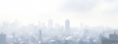 Blurred city skyline under a cloudy sky creating a serene atmosphere. clipart