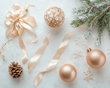 Elegant holiday decorations with gold ornaments and ribbons on a snowy surface.