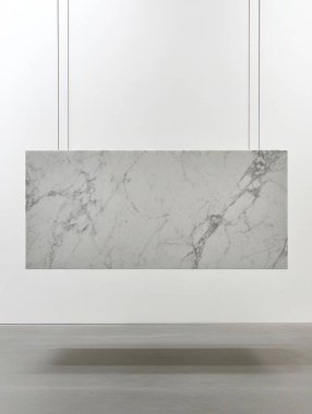 Minimalist marble art piece suspended in a bright gallery space.