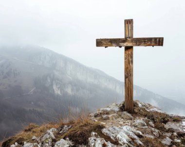 Yıpranmış ahşap bir haç, sisli dağlarla çevrili kayalık bir çıkıntıda dimdik duruyor. Huzur ve yalnızlık hissi uyandırıyor..