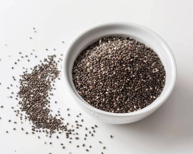 Close-up of black chia seeds in a white bowl, showcasing their texture and vibrant color against a clean background. clipart