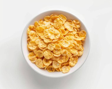 A close-up view of a white bowl filled with crispy banana chips, showcasing their golden color and unique texture. clipart