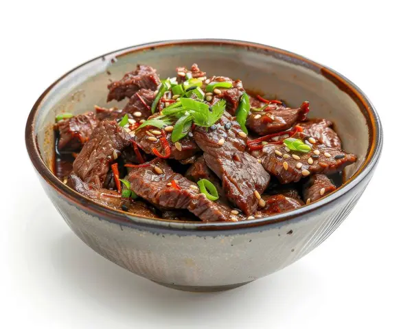 A bowl of savory beef stir-fry topped with green onions and sesame seeds.