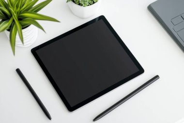 Minimalist Tablet ve Kalem Modeli Bitkili Temiz Beyaz Masa Üzerinde