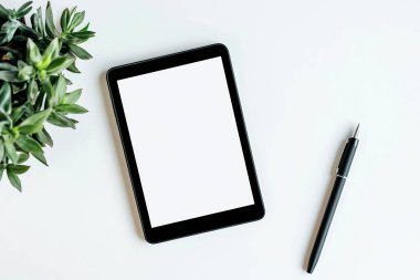 Minimalist Tablet ve Kalem Modeli Bitkili Temiz Beyaz Masa Üzerinde