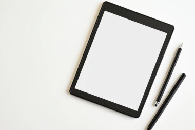 Minimalist Tablet ve Kalem Modeli Bitkili Temiz Beyaz Masa Üzerinde