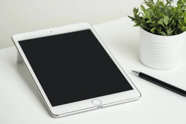 Minimalist Tablet ve Kalem Modeli Bitkili Temiz Beyaz Masa Üzerinde