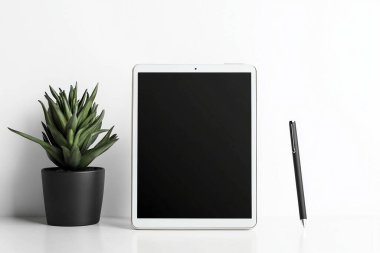 Minimalist Tablet ve Kalem Modeli Bitkili Temiz Beyaz Masa Üzerinde