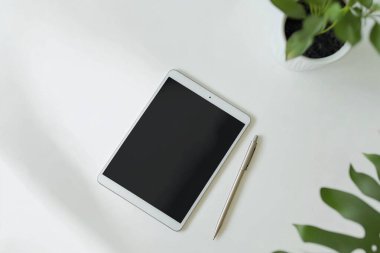 Minimalist Tablet ve Kalem Modeli Bitkili Temiz Beyaz Masa Üzerinde