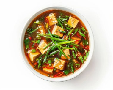 A vibrant bowl of tofu soup featuring fresh green onions and chili peppers, exuding a warm and inviting aroma. clipart