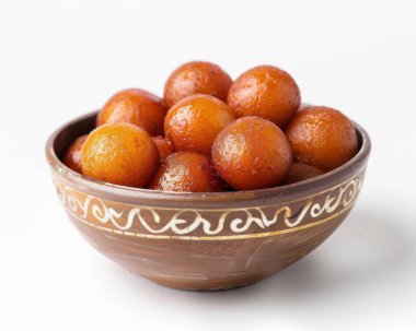 Deliciously sweet and golden gulab jamun served in a traditional clay bowl. clipart