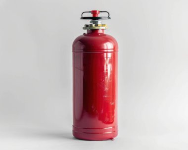 A red fire extinguisher standing vertically against a light background, symbolizing safety and fire protection.