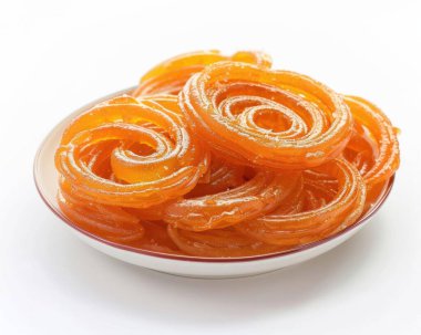 A vibrant plate of golden, spiral-shaped jalebi, a popular Indian sweet, coated in sugary syrup. clipart