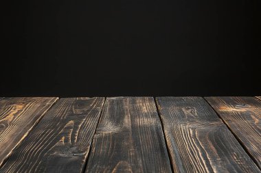 wooden table top on black background.