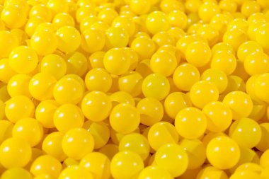 A vibrant collection of shiny yellow balls scattered together. clipart