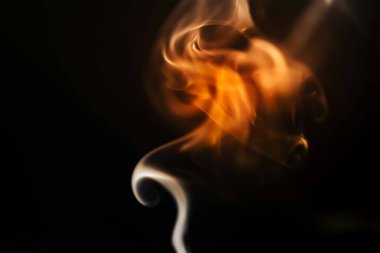 Abstract swirl of orange and white smoke on a dark background. clipart