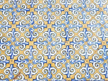 Colorful ornate tile pattern with blue swirls on a warm yellow background. clipart