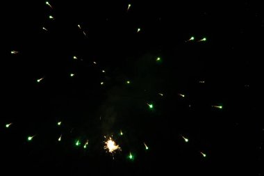 A brilliant display of green fireworks lighting up the night sky. clipart