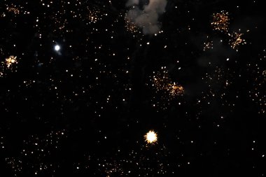 Vibrant fireworks sparkle against the dark night sky. clipart