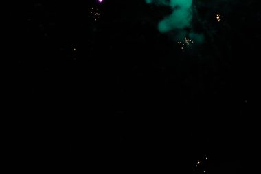 Colorful fireworks bursting in the night sky with vibrant purple and green hues. clipart