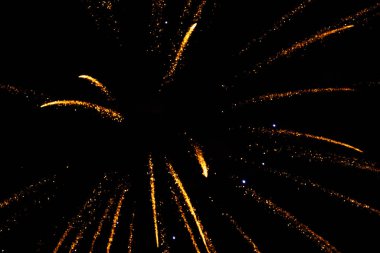 Golden fireworks burst against a dark night sky, creating a festive atmosphere. clipart