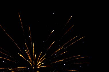 Golden fireworks bursting in a night sky, creating a festive atmosphere. clipart