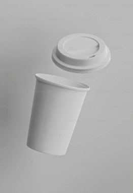 Minimalist white coffee cup with lid, floating against a gray background. clipart