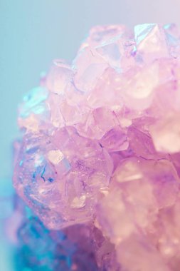 Close-up of a beautiful purple crystal against a soft pastel background. clipart