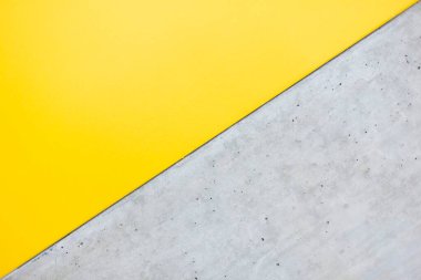 A vibrant yellow and cool concrete surface create a striking contrast. clipart