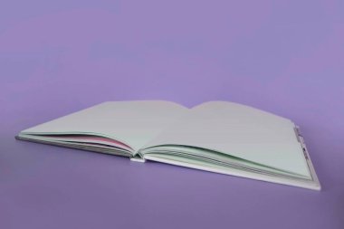 An open blank notebook on a pastel purple background. clipart