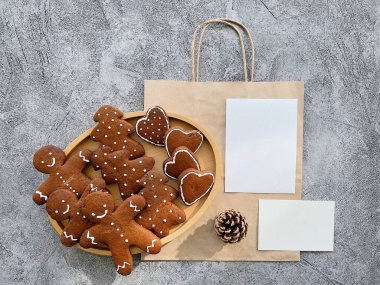 Gingerbread cookies with festive shapes displayed on a wooden plate. clipart