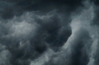 Dark storm clouds swirling in a dramatic sky. clipart