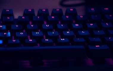 Close-up of a gaming keyboard with vibrant neon lighting. clipart