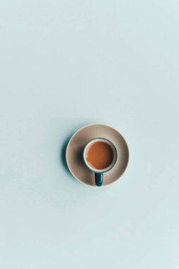 A clean, minimalist overhead view of a coffee cup with saucer on a smooth surface. clipart