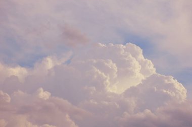 Fluffy white clouds drifting in a pastel sky. clipart