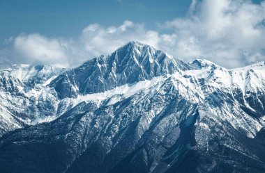 Majestic snow-covered mountains under a clear blue sky. clipart