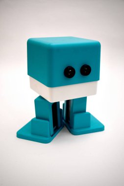 A playful turquoise robot-shaped paper stapler standing against a plain background. clipart