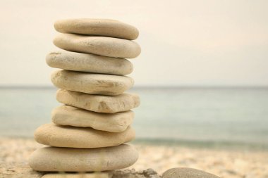 A serene stack of smooth beige stones by the tranquil shore. clipart