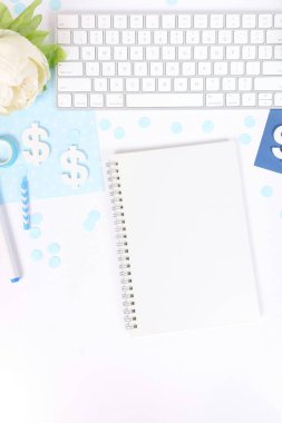 White workspace with notebook, keyboard, and blue decorations. clipart